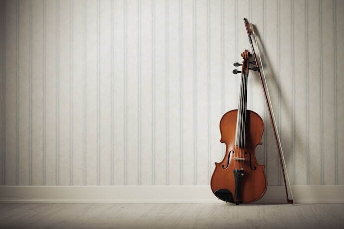 Violino encostado em parede listrada