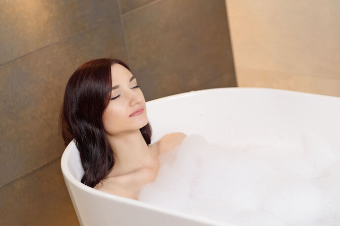 Mulher relaxando tomando banho com espuma