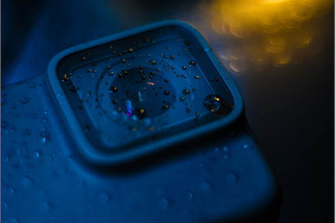 Uma lente de camera visto de perto com gotas de chuva