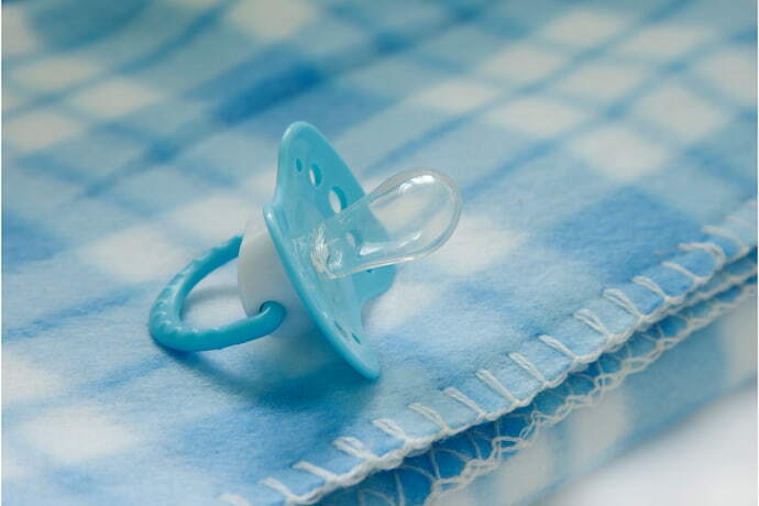 Cobertor para bebê listrado azul com chupeta azul.