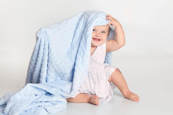 Bebê enrolado em cobertor azul.