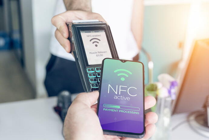 Pessoa com celular com NFC fazendo pagamento
