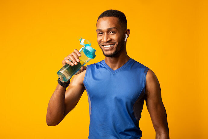 Homem esportivo bebendo água na sua garrafa