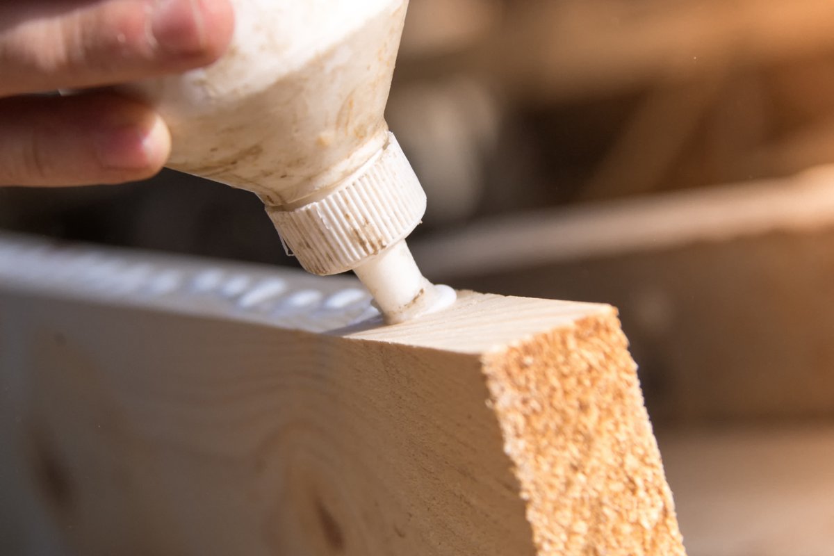Carpinteiro colocando cola em uma pedaço de madeira