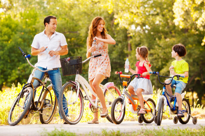 Adultos e crianças de tamanhos diferentes com suas bicicletas