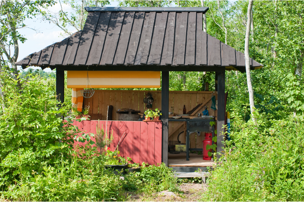 Cozinha externa simples coberta e ao redor floresta.