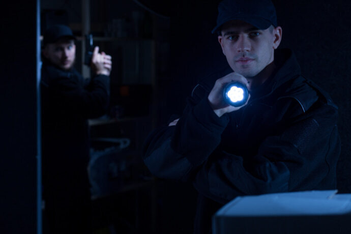 Policial segurando lanterna tática.