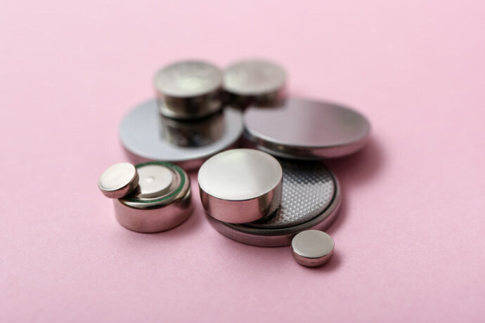 Baterias de botão de lítio em fundo rosa.