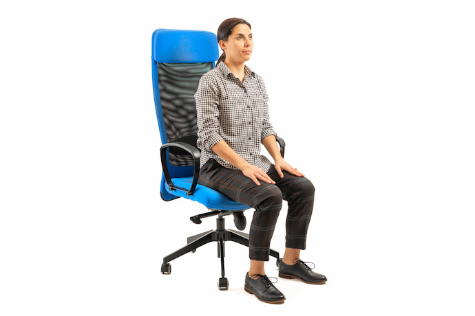 Mulher sentada na cadeira do escritório e se alongando.