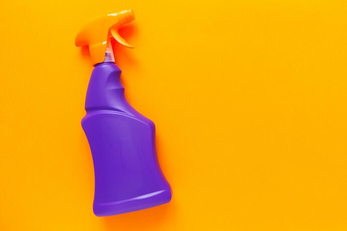 Spray de detergente em fundo laranja