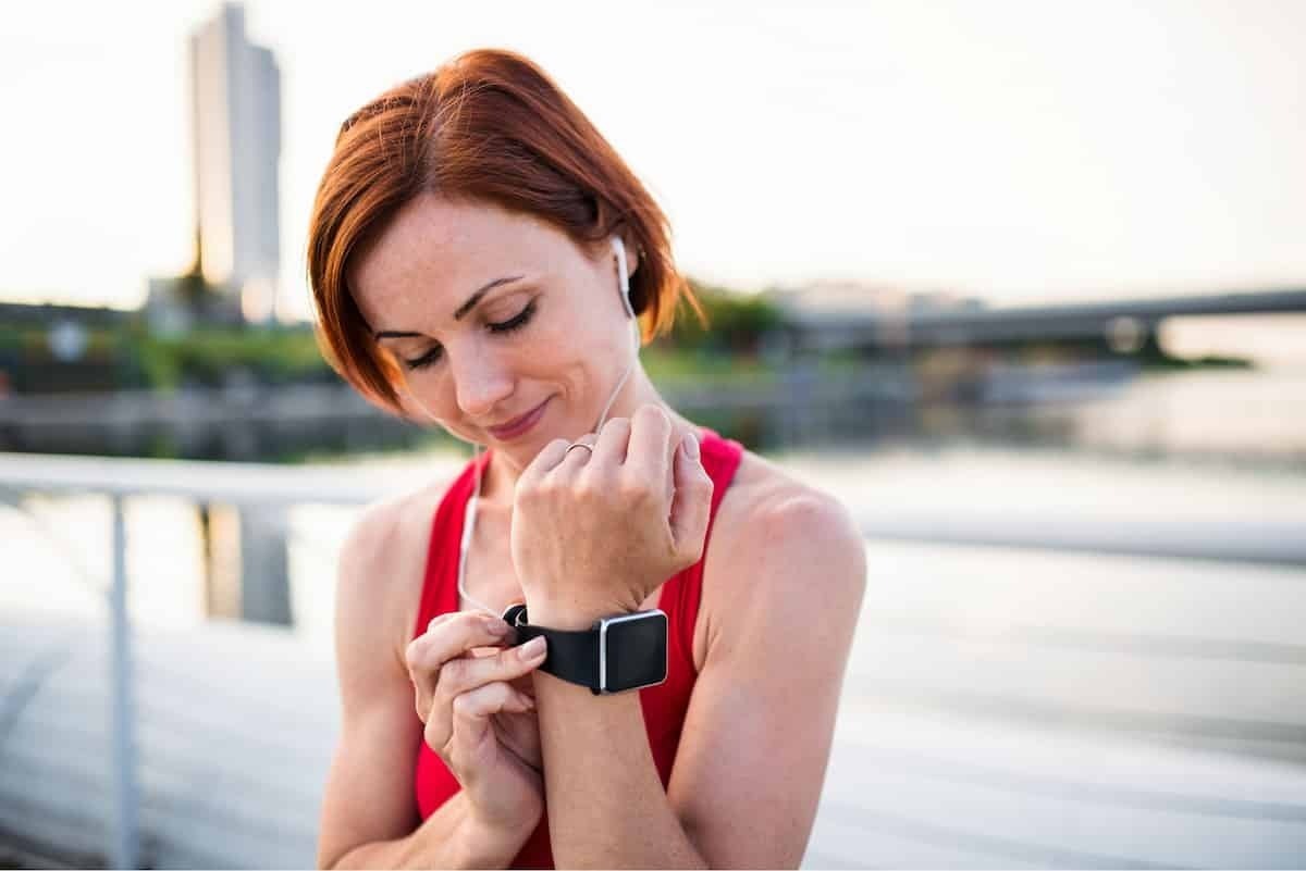 Mulher esportiva arrumando smartwatch