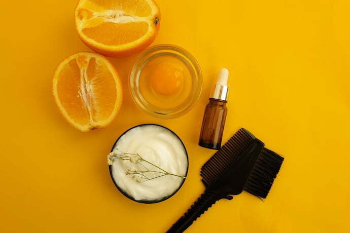 Máscara de hidratar cabelo, outros ingredientes e fundo laranja