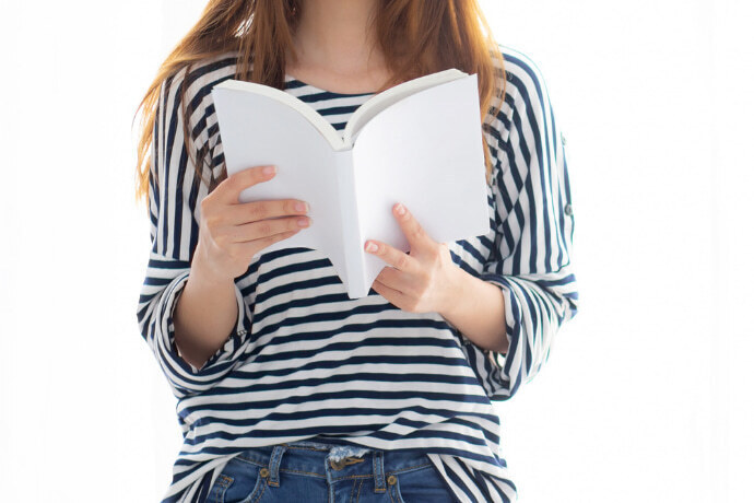 Mulher estudando inglês com auxílio de um livro