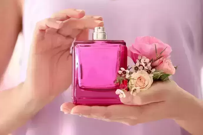 Mulher segurando perfume e flores