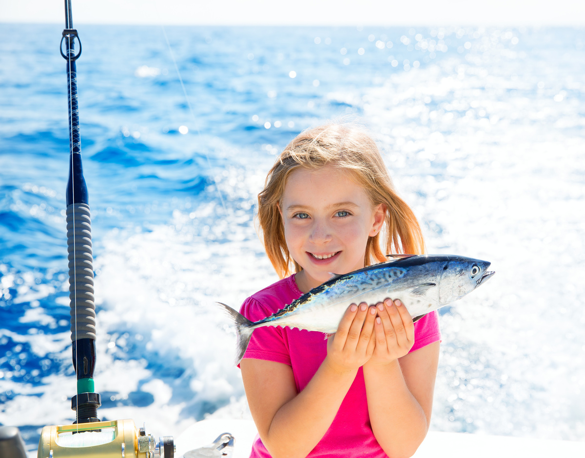 Menininha pescando um peixe bonito pequeno