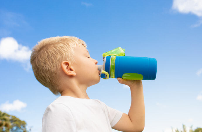 Criança bebendo água de garrafa