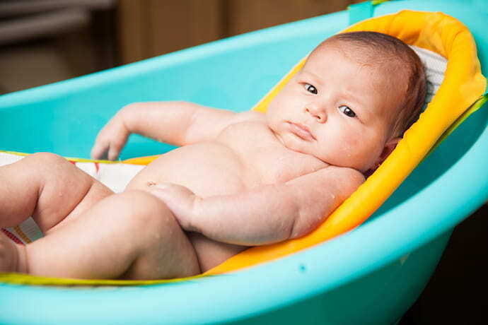 Bebê dentro de banheira em assento redutor