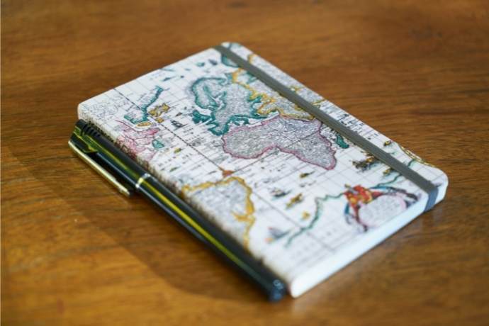 Caderno bullet journal com elástico e com uma caneta ao lado