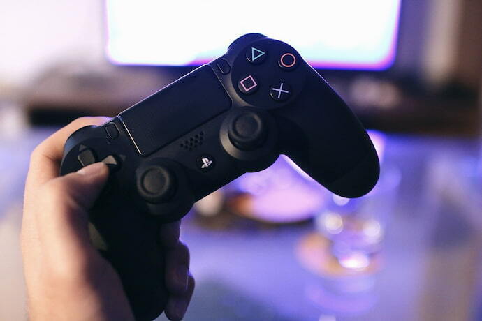 Mão segurando um controle PS4