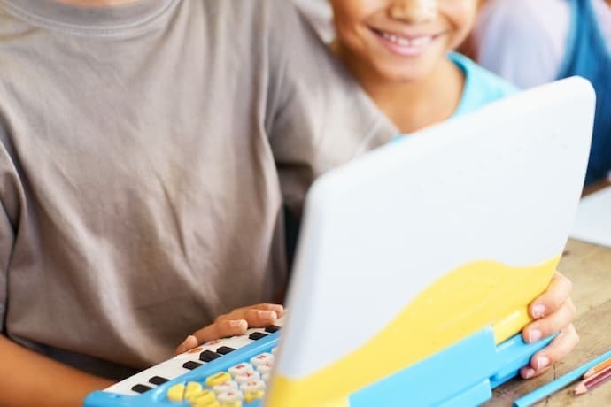 Crianças brincando com laptop infantil