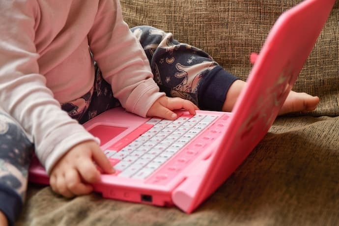 Criança brincando com laptop infantil 