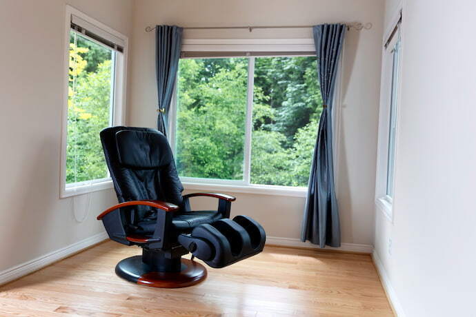 Cadeira de massagem em cômodo vazio com janelas abertas