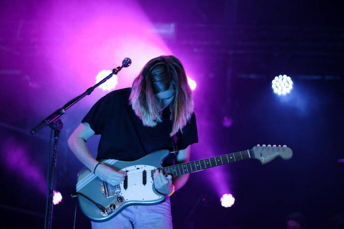 Mulher tocando guitarra em palco