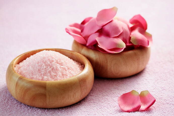 Dois potes, um com sal de banho e um com flores rosas