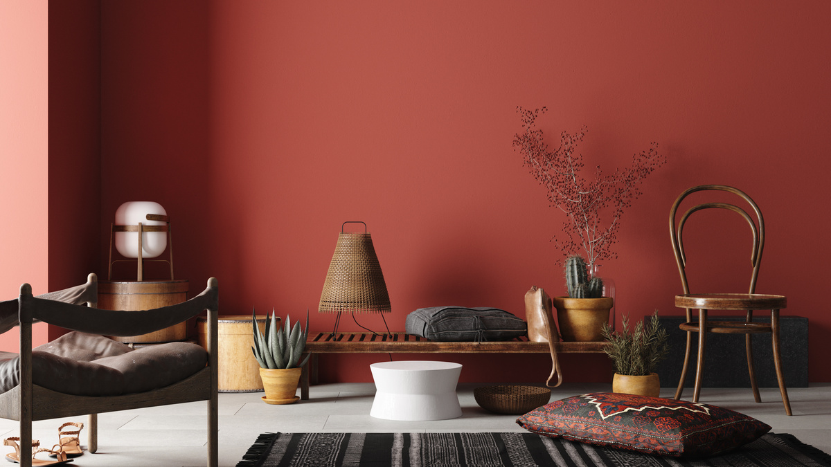 Sala com sofá marrom e parede avermelhada
