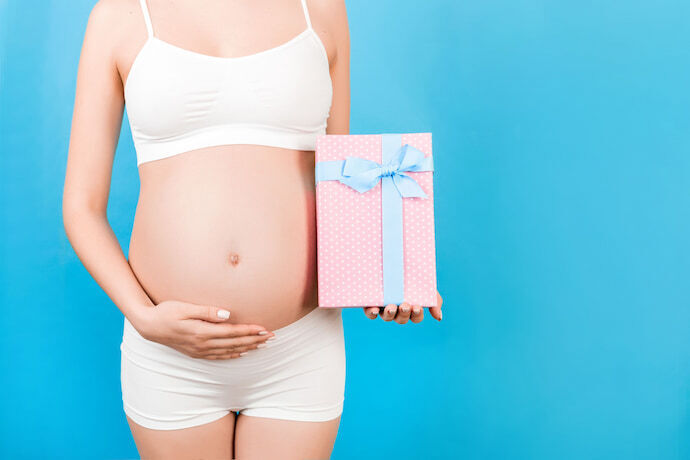 Mulher grávida segurando presente