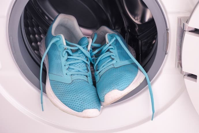Tênis de corrida em uma máquina de lavar roupa
