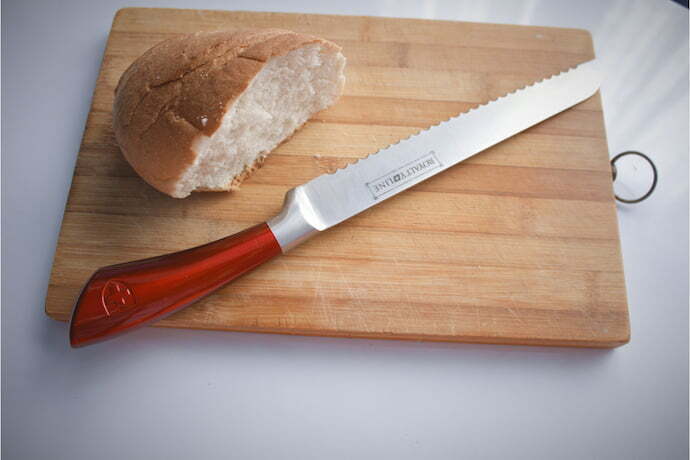 Uma tábua com faca de pão e um pão.