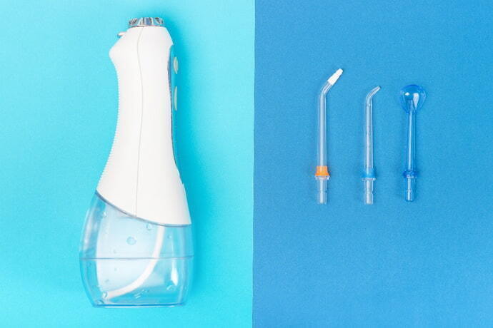 Irrigador dental em fundo azul