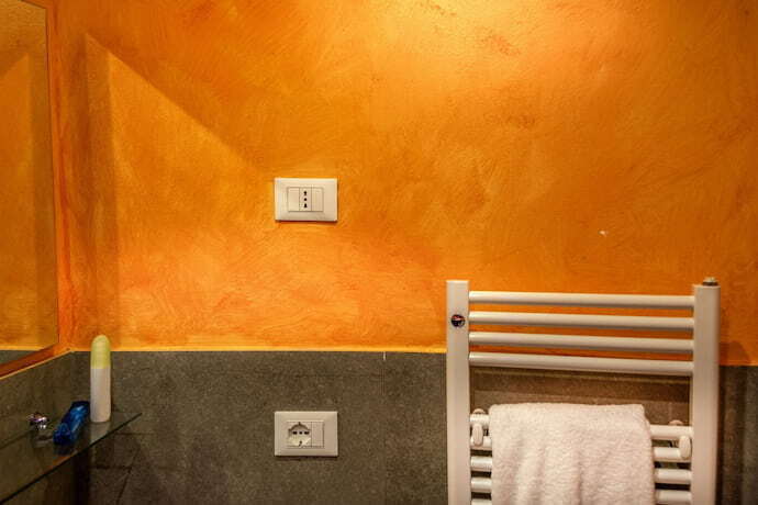 aquecedor de toalha e uma parede laranja