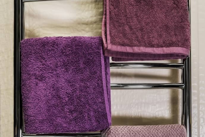 Toalhas roxas em um aquecedor de toalha