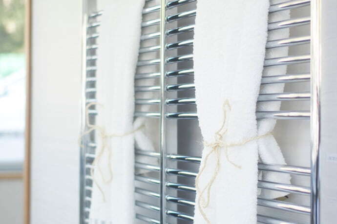 aquecedor de toalha com toalha branca e espelho