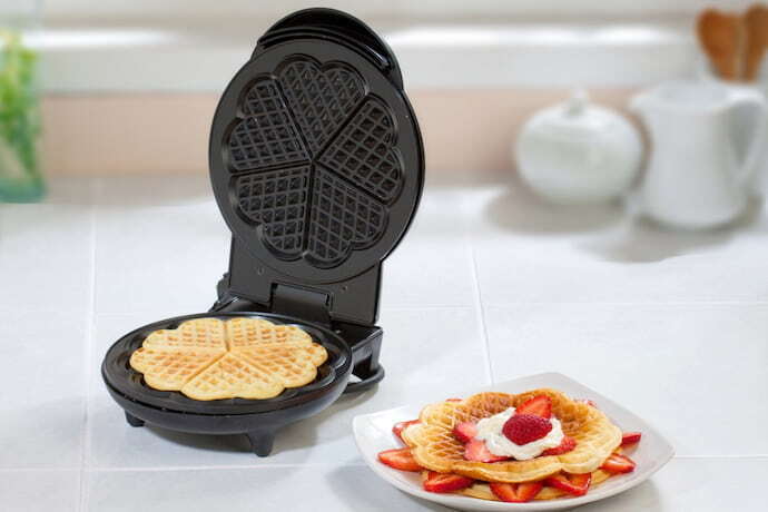 máquina de waffle e prato com waffle ao lado