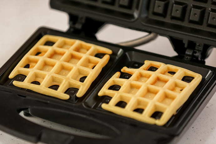 máquina de waffle preta e aberta com waffle
