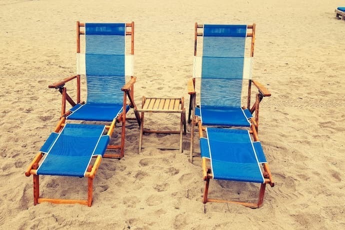 Duas cadeiras azuis na praia