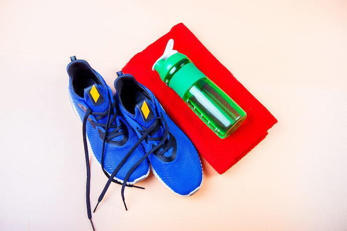 tênis New Balance azul, pano vermelho e garrafa de agua