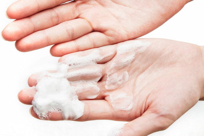 Mãos com espuma de limpeza