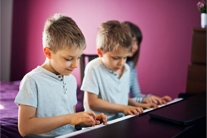 2 meninos tocando Piano Digital