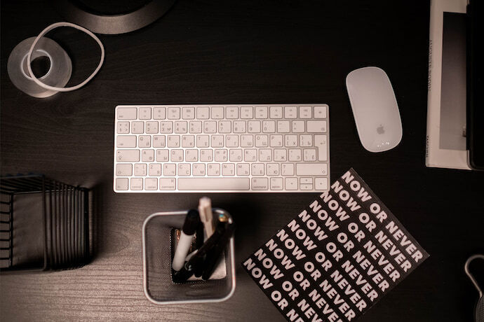 Mesa de escritório com alguns itens e teclado de notebook