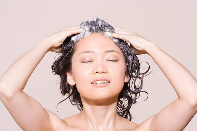 Mulher lavando cabelo com shampoo em barra.