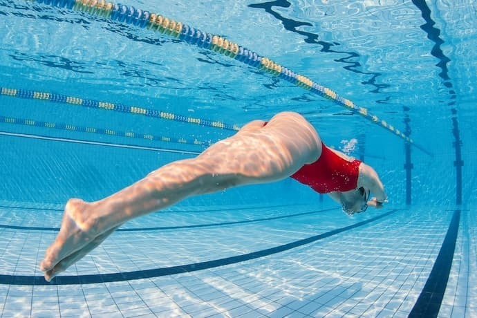 Nadadora na piscina usando maiô
