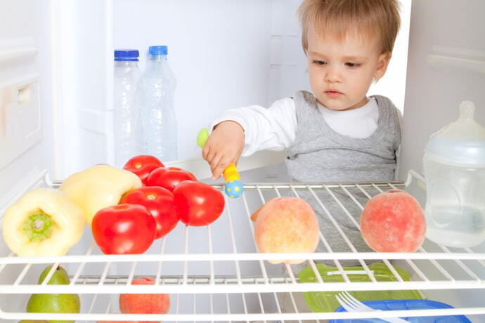 Criança pegando algo da geladeira