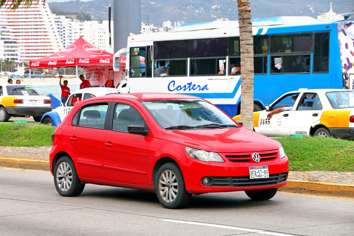 Parte frontal e lateral do Carro do modelo Volkswagen Gol 1.6 AT, de cor vermelho.