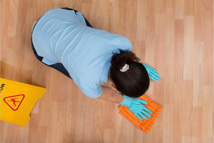 Mulher limpando o chão e uma placa