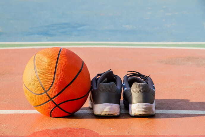 Tênis e bola de basquete em quadra.