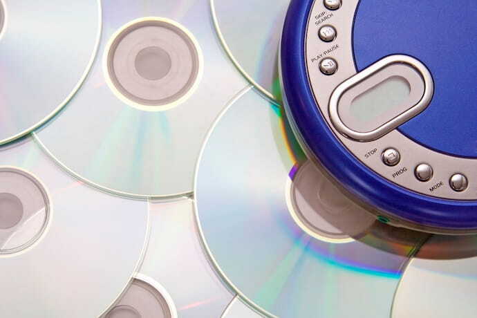 CD player portátil com diversos CD's espalhados